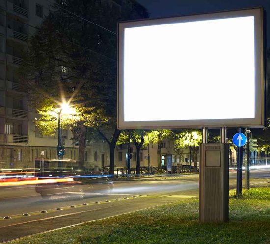 Mega-Light-Poster an einer befahrenen Straße bei Nacht
